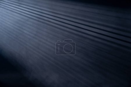 Téléchargez les photos : Rayons lumineux traversant les stores isolés sur fond noir avec espace de copie - en image libre de droit