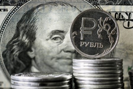 Ruble coin on background of USA dollar bill, Russian ruble money is under sanctions. Concept of economy crisis, finance of Russia, currency exchange rate, inflation, politics and ruble payment.