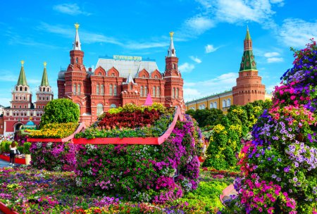 Photo for Flowers in Moscow, Russia. Scenic view of Historical Museum (it's written on roof) and Moscow Kremlin in background. Scenery of beautiful garden in Moscow city center. Travel and tourism in Russia. - Royalty Free Image