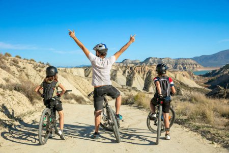 Téléchargez les photos : Heureux père avec enfants vélo, famille profiter concept de balade à vélo - en image libre de droit