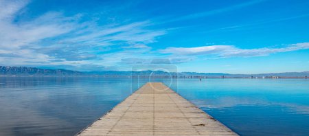 Foto de Muelle de madera, hermoso lago azul y reflejo de nubes (Delta del Ebro, España)) - Imagen libre de derechos