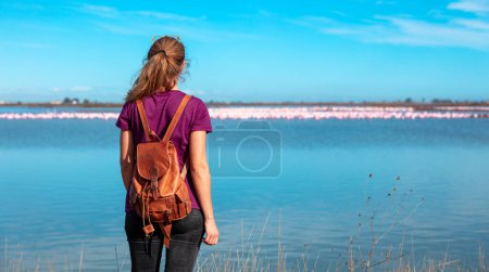Téléchargez les photos : Femme touriste regardant le troupeau de flamant rose en Espagne (Delta del Ebro) - en image libre de droit