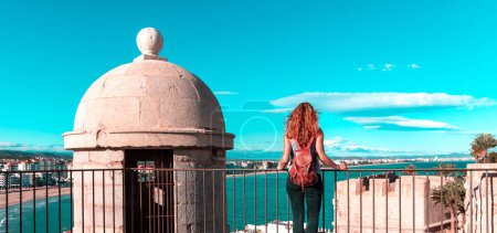 Téléchargez les photos : Paysage de la ville de Peniscola et belle plage, touriste femme bénéficiant d'une vue panoramique - en image libre de droit