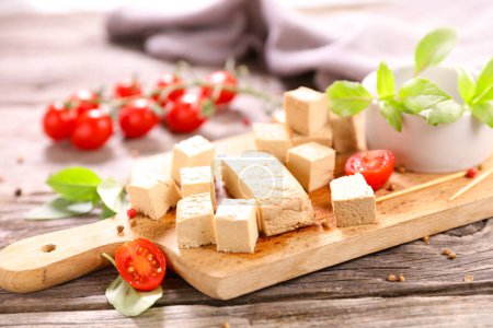 Photo for Tofu cube and tomato on wooden board - Royalty Free Image