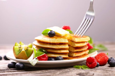 Photo for Stack of pancakes with fresh fruits and fork - Royalty Free Image