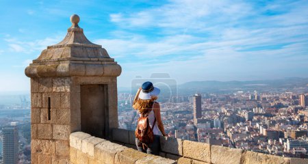 Foto de Traveler woman looking at panoramic spanish city landscape from Santa Barbara castle- Alicante - Imagen libre de derechos