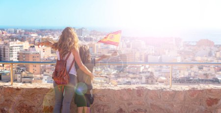 Téléchargez les photos : Woman and son holding Spain flag and looking at Almeria city panoramic - en image libre de droit