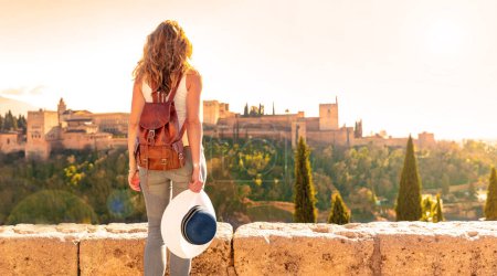 Foto de Woman tourist looking at Ancient arabic fortress Alhambra- Granada in Spain - Imagen libre de derechos