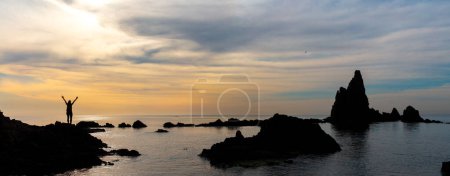 Photo for Seascape in Almeria, and woman silhouette at sunset- Cabo de Gata, National Park, Spain ( reef of the sirens) - Royalty Free Image