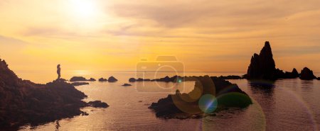 Téléchargez les photos : Sunset at the sea with rocks and woman silhouette - en image libre de droit