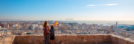 Téléchargez les photos : Mother and son with spanish flag looking at panoramic city landscape in Spain- Andalusia, Almeria - en image libre de droit