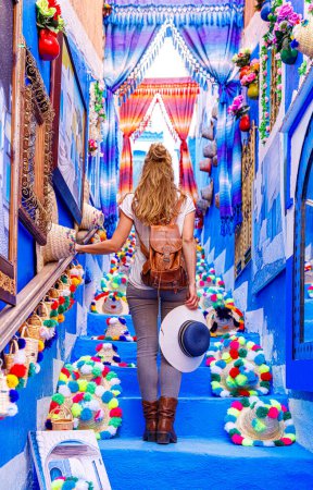 Téléchargez les photos : Tourisme à Chefchaouen, femme avec sac à dos explorer la ville marocaine typique bleue - en image libre de droit