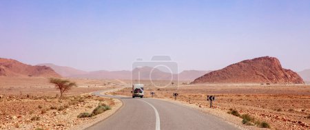 Téléchargez les photos : Road trip au Maroc Camping-car sur la route dans un paysage désertique - en image libre de droit