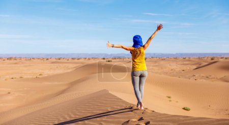 Foto de Turista mujer caminando sobre dunas de arena en el desierto del Sahara - Imagen libre de derechos