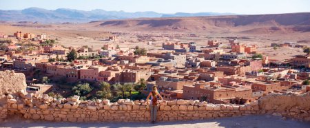 Téléchargez les photos : Ait Ben Haddou dans les montagnes de l'Atlas du Maroc et touriste en regardant la vue - en image libre de droit