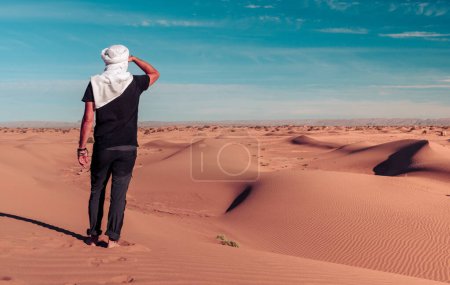 Foto de Turista hombre vistiendo turbante blanco en el desierto del sahara-turismo en Marruecos - Imagen libre de derechos