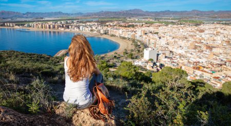 Photo for Woman tourist looking at panoramic view of city landscape of Aguilas near Murcia in Spain - Royalty Free Image