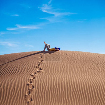 Photo for Woman relaxing on a sand dune - Royalty Free Image