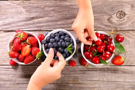 Photo for Hand holding blueberry and cherry fruits- various of berries fruits - Royalty Free Image