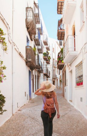 Téléchargez les photos : Vue arrière de la femme marchant dans la rue espagnole - en image libre de droit