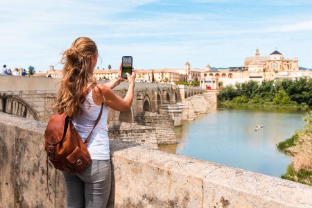 Téléchargez les photos : Femme prenant des photos avec smartphone la vue sur la ville de Cordoue - Espagne, Andalousie - en image libre de droit