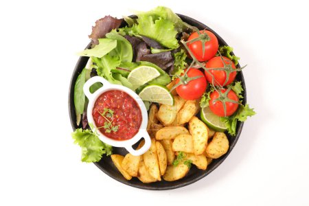 Téléchargez les photos : Cales de pommes de terre cuites au four avec des légumes et sauce épicée - en image libre de droit