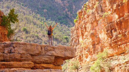 Téléchargez les photos : Femme heureuse sur la falaise dans le canyon rouge- Aguadir au Maroc - en image libre de droit