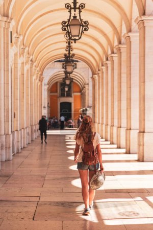 Téléchargez les photos : Femme marche à la célèbre arche au Praca do comercio, Portugal - en image libre de droit