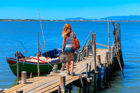 Téléchargez les photos : Porto Palafita da Carrasqueira, Femme marchant sur une jetée de pêche en bois Portugal antique - en image libre de droit