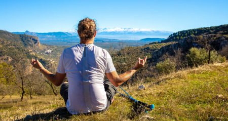 Foto de Caminante sentado mirando a la montaña- viajes, deporte, relajación, saludable concepto de estilo de vida activo - Imagen libre de derechos