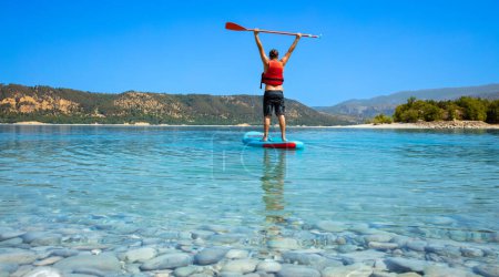 Téléchargez les photos : Happy man debout sur le paddle board sur le lac (France, Gorges du Verdon) - en image libre de droit