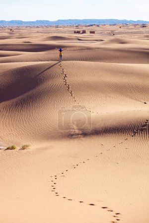Foto de Paisaje de dunas de arena en el desierto, pisada y sola mujer- viajes, libertad, concepto de aventura - Imagen libre de derechos