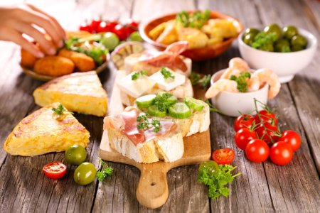 Photo for Spanish tapas- toast with prosciutto ham and assortment food - Royalty Free Image