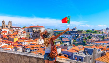Téléchargez les photos : Femme touriste tenant le drapeau portugais devant le point de vue panoramique du paysage urbain Porto, Portugal - en image libre de droit