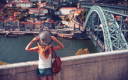 Foto de Turista mujer con vistas panorámicas del paisaje urbano de Oporto, el río Douro y el famoso puente Portugal - Imagen libre de derechos