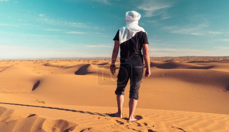 Foto de Hombre viajero de pie y contemplando la duna de arena, el desierto del sahara Marruecos - Imagen libre de derechos