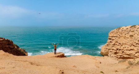 Photo for Woman with flying hair in the wind in front of atlantic ocean- carefree,  freedom, vacation lifestyle concept - Royalty Free Image