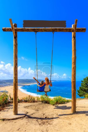 Téléchargez les photos : Enfant et mère sur un swing en face de la mer- Portugal - en image libre de droit
