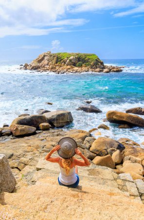 Foto de Mujer contemplando la formación de rocas insulares en el océano atlántico- Galicia, España - Imagen libre de derechos