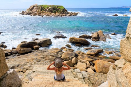 Photo for Woman contempling island rock formation in atlantic ocean- Galicia,  Spain - Royalty Free Image