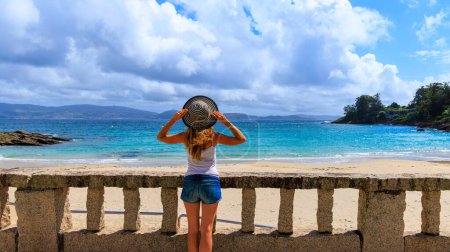 Photo for Young woman with hat enjoying panoramic view of atlantic ocean- Galicia,  Spain - Royalty Free Image