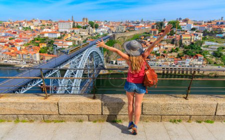 Téléchargez les photos : Femme touriste avec bras levés profitant d'une belle vue sur la ville de Porto et célèbre pont en fer- destination de voyage d'été, vacances, tourisme au Portugal - en image libre de droit