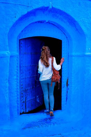 Téléchargez les photos : Tourisme au Maroc-Femme touriste dans belle rue bleue à Chefchaouen - en image libre de droit