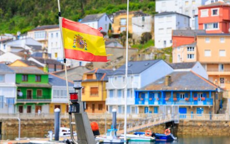 Foto de Bandera de España en el pueblo de Galicia con coloridas casas- Viajar en España - Imagen libre de derechos