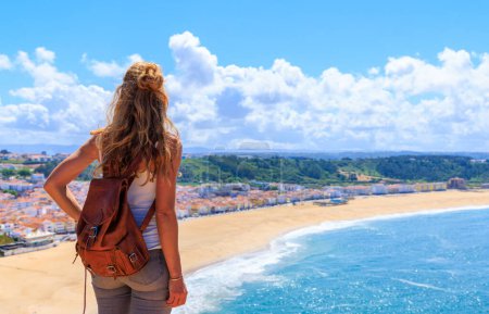 Photo for Woman tourist enjoying panoramic view of beach and atlantic ocean coast- Nazare,  Portugal - Royalty Free Image