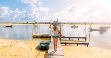 Woman walking on wooden pier,  beautiful beach and fishing boats- Arcachon basin,  France, Basque country