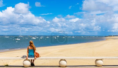 Téléchargez les photos : Femme assise sur un banc regardant la vue panoramique sur l'océan Atlantique France, Arcachon, Pays basque - en image libre de droit