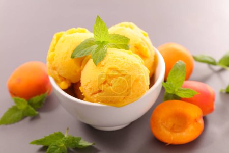 Téléchargez les photos : Boule de crème glacée abricot dans le bol été rafraîchissant - en image libre de droit