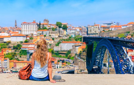 Téléchargez les photos : Femme touriste profitant du paysage sur la vieille ville avec rivière et célèbre pont à Porto ville- Portugal - en image libre de droit