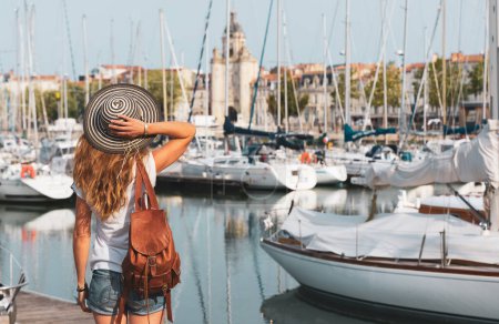 Téléchargez les photos : Femme visitant le vieux port et la ville de La Rochelle. Charente-Maritime en France - en image libre de droit